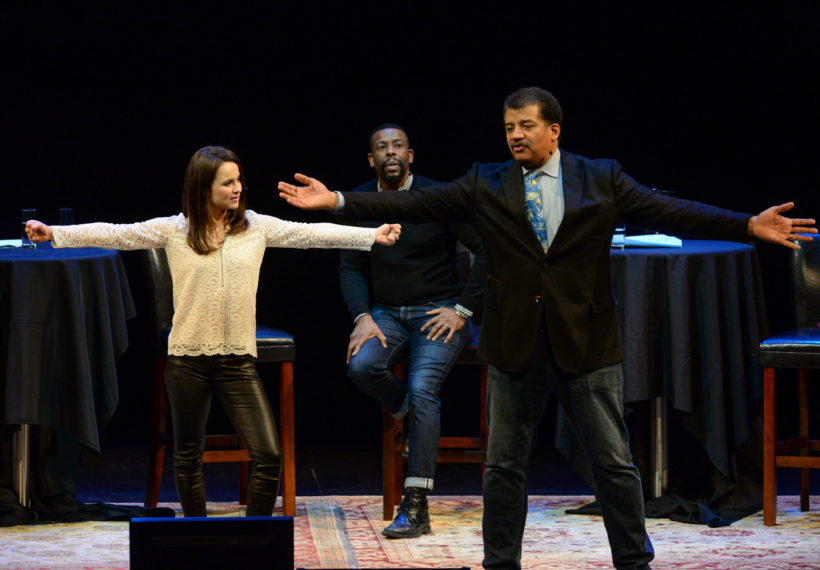 Elliot Severn’s photo of Sasha Cohen and Neil deGrasse Tyson demonstrate spins onstage at BAM, while host Chuck Nice looks on.