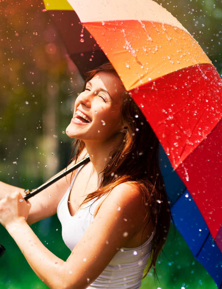 Storyblock’s photo of a laughing woman with an umbrella in the rain.
