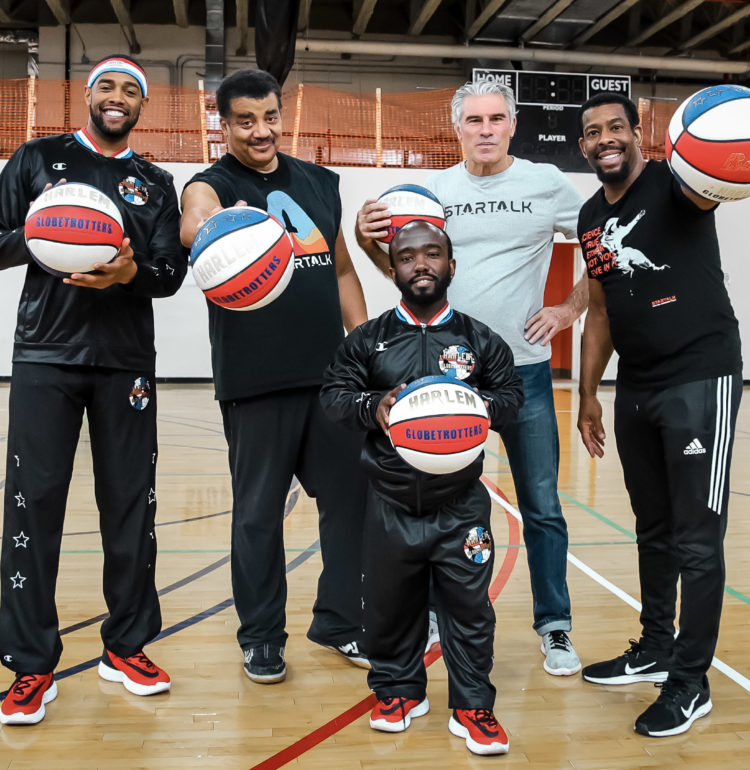 StarTalk Sports Edition team with two members of the Harlem Globetrotters posing with basketballs.